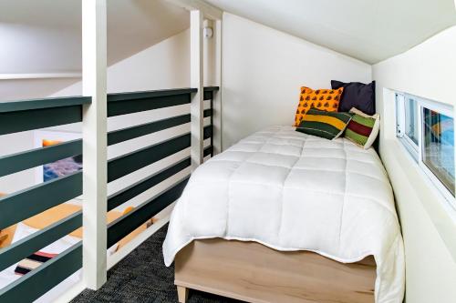 a small bedroom with a bed and a staircase at Madbush Falls in Waitsfield