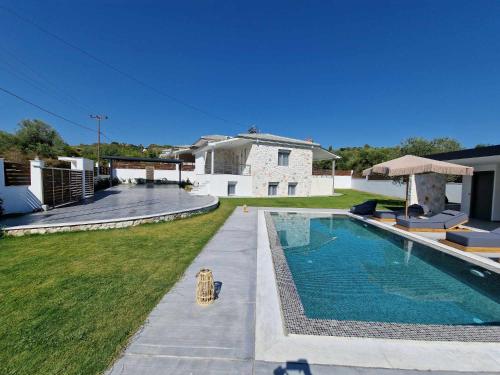 Un patio trasero con piscina y una casa. en Villa Hillside Pefkohori, en Pefkohori