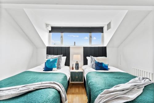 2 camas individuales en una habitación con ventana en Large 4 bed in Leeds - Sleeps 10 - Parking, en Leeds