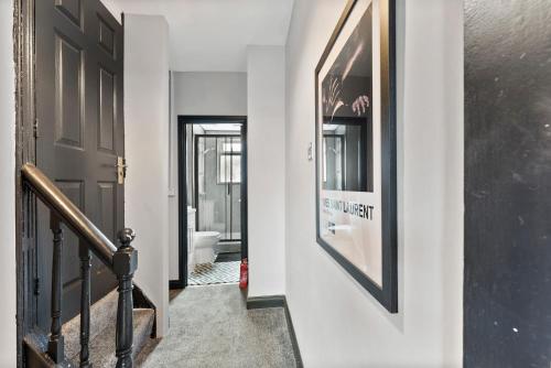 a hallway with a black door and a stair case at Large 4 bed in Leeds - Sleeps 10 - Parking in Leeds