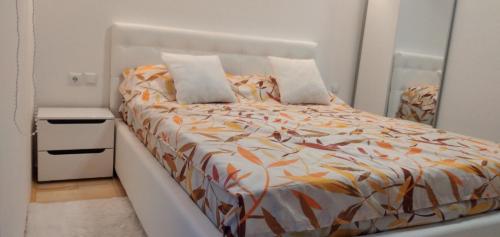 a bedroom with a bed with an orange and white comforter at Farah House in Sarajevo