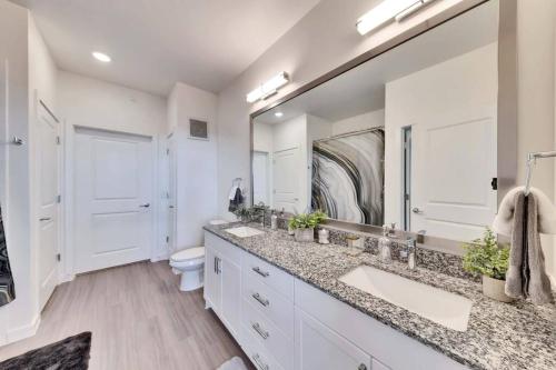 a bathroom with two sinks and a large mirror at Charming 1 BR Austin Oasis-Perfect for your vacation! in Kyle