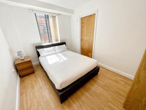 a small bedroom with a bed and a window at Minimalist space - Manchester City Centre in Manchester