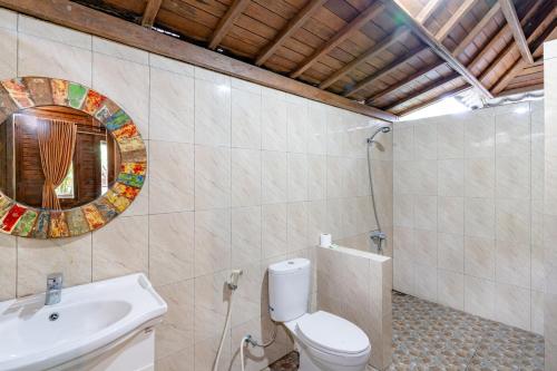 ein Badezimmer mit einem WC, einem Waschbecken und einem Spiegel in der Unterkunft Green Villas Lembongan by ABM in Nusa Lembongan