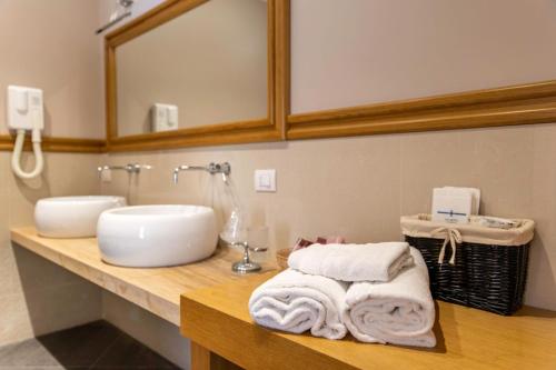 a bathroom with a sink and towels on a counter at Hotel Il Barocco in Ragusa