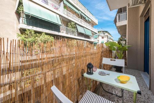 a table and chairs on a balcony with a fence at Sweet home in Koukaki in Athens