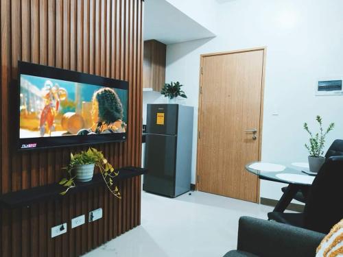 a living room with a flat screen tv on a wall at 2BR SMDC Bloom Residences Near NAIA Wi-fi +Netflix in Manila