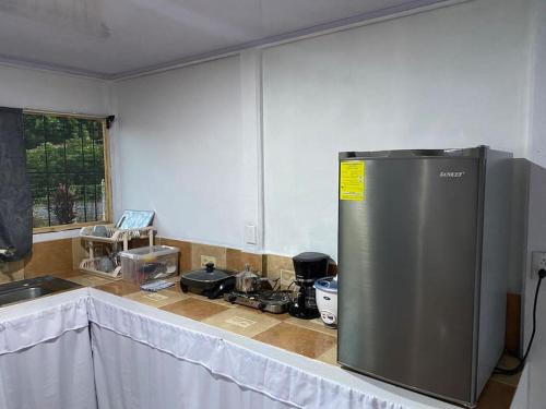 eine Küche mit einem Kühlschrank aus Edelstahl auf einer Theke in der Unterkunft Casa de campo entera rodeada de naturaleza en Sarapiquí in Heredia