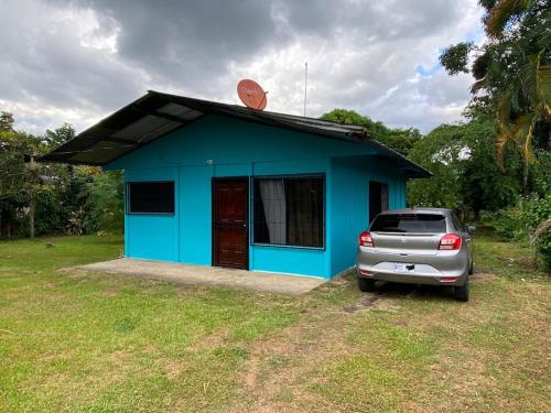 ein blaues Haus mit einem davor geparkt in der Unterkunft Casa de campo entera rodeada de naturaleza en Sarapiquí in Heredia