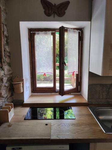 a kitchen with a window in the middle of a kitchen at La baita alpina in Scopello