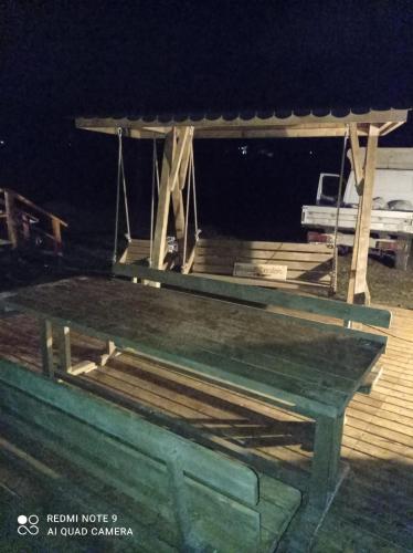 a picnic table on a dock at night at Popasul Dacilor in Predeluţ