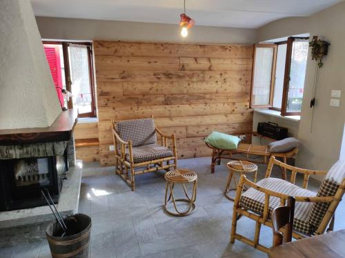 una sala de estar con chimenea y paredes de madera. en La baita alpina, en Scopello