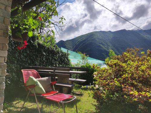two chairs and a bench with a view of a mountain at La baita alpina in Scopello