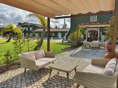 un patio con sedie e tavoli e una casa di Quinta do Pinheiro Hotel Rural - GQL a Valado dos Frades