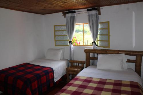 a bedroom with two beds and a window at Rancho Ventura in Filandia