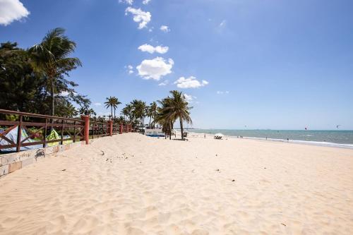 a sandy beach with palm trees and the ocean at [KaririBeach319] Incrível Flat 2qts à beira-mar in Cumbuco