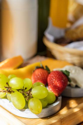 a plate of fruit on a wooden table at Bravo Pousada Design in Cabo Frio