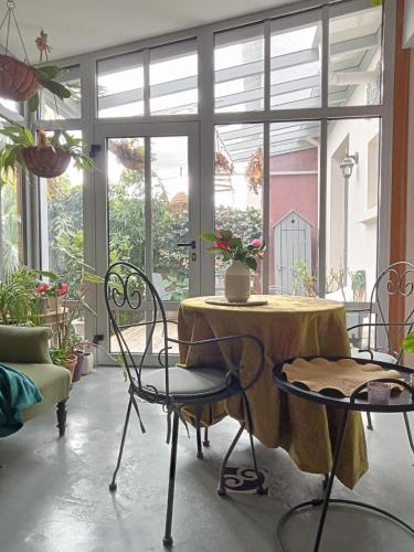 a table and chairs in a room with windows at chambre indépendante sur jardin avec SDE et cuisine in Nantes