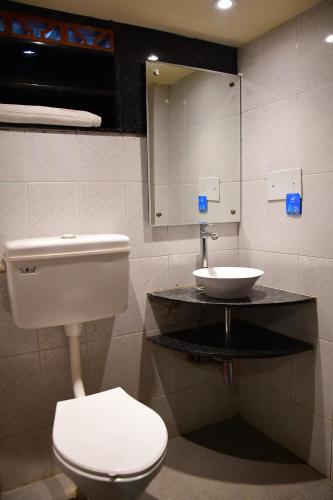 a bathroom with a toilet and a sink at Hotel Shripad Continental in Amrāvati