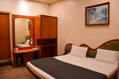 Pokój hotelowy z łóżkiem i lustrem w obiekcie Hotel Shripad Continental w mieście Amravati