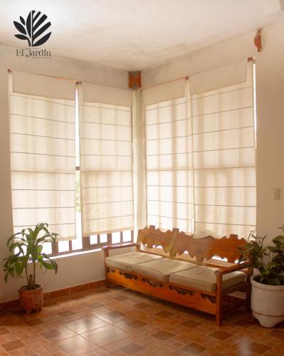 une chambre avec un canapé en face des fenêtres dans l'établissement Departamento El Jardín, à Xocoyolo