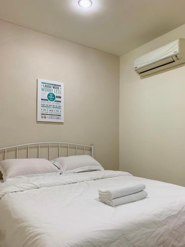 a bedroom with a bed with towels on it at Hotel Bajet Pulai in Ipoh