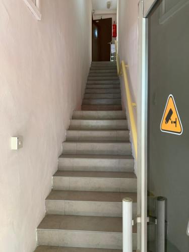 a staircase in a building with a caution sign at Hotel Bajet Pulai in Ipoh