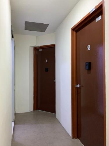 an empty hallway with two doors in a building at Hotel Bajet Pulai in Ipoh