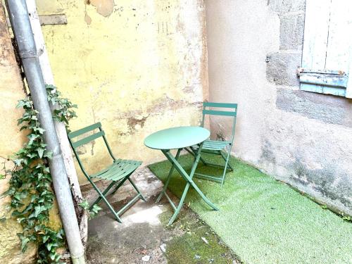 a table and two chairs sitting next to a wall at Appartement cosy Centre ville in Moulins