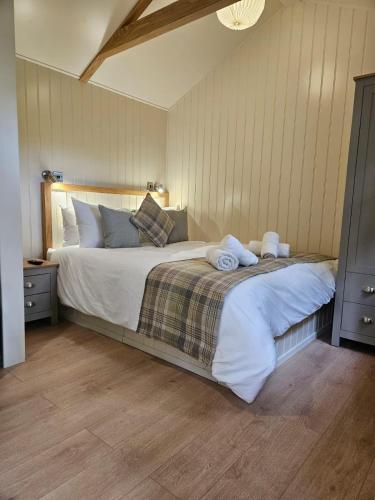 a bedroom with a large bed with towels on it at Woodland Shepherds Hut - 'Saga' in Caernarfon