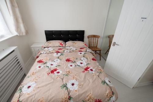 a bedroom with a bed with a floral bedspread at OAK AVENUE HOME in Shirley