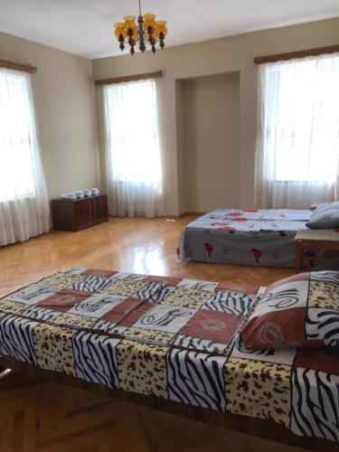two beds sitting in a room with windows at Guesthouse "KISTAURI" in Telavi