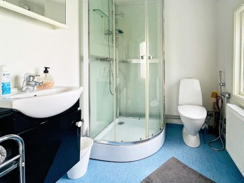 a bathroom with a shower and a toilet and a sink at Holiday home NÖDINGE 