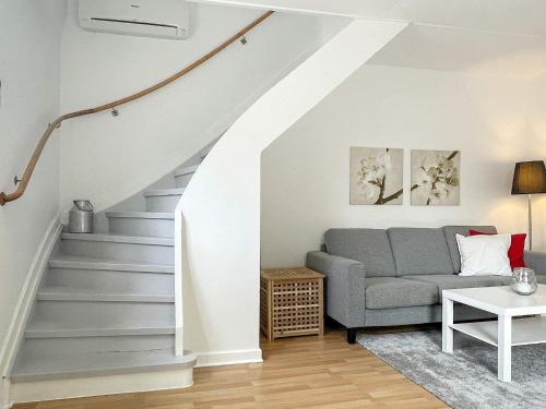 a living room with a gray couch and stairs at 4 person holiday home in TRENSUM-By Traum in Trensum