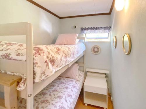 a small bedroom with two bunk beds and a window at Holiday home HUNVIGAN in Höllviken