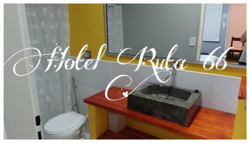 a bathroom with a toilet and a sign that reads a picture kitchen at Hotel Ruta 66 Oficial in Paso de los Libres