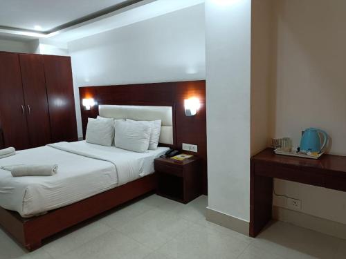 a bedroom with a large bed and a wooden headboard at Hotel Autumn Crocus in Guwahati