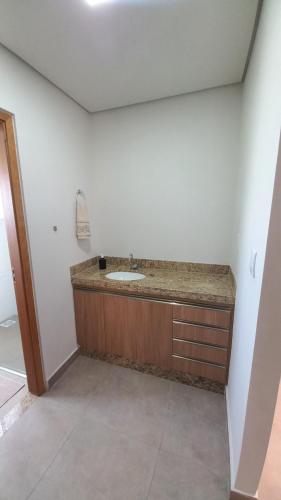 uma casa de banho com um lavatório num quarto em Flat MP em Araxá