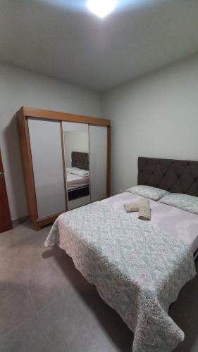 um quarto com uma cama grande e um espelho em Flat MP em Araxá