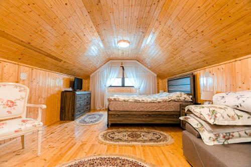 a bedroom with two beds and a chair in a room at Pensiunea Casa de Vis in Cîmpulung