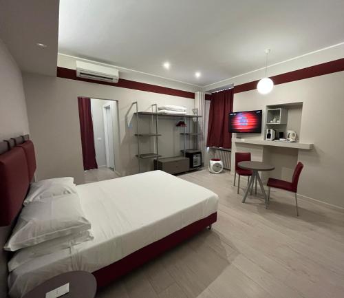 a bedroom with a bed and a table and a tv at Borgo Yporegia in Ivrea