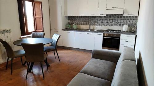 a living room with a table and a couch and a kitchen at La Dimora Degli Etruschi in Celle sul Rigo
