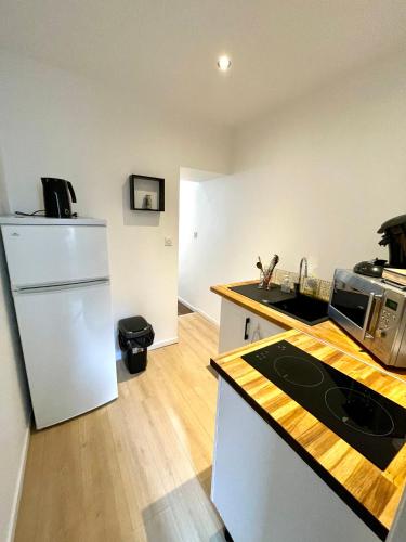 une cuisine avec un réfrigérateur blanc et un plan de travail dans l'établissement Appartement cosy Centre ville, à Moulins