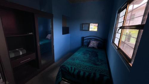 Habitación azul pequeña con cama y ventana en Casa Esther, 