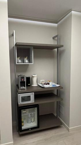 a kitchen with a shelf with a microwave at Borgo Yporegia in Ivrea