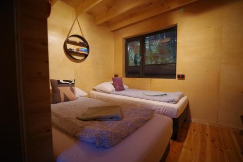 Duas camas num quarto com uma janela em Ski House Szczyrk - Domek Na Kurzej Łapce em Szczyrk