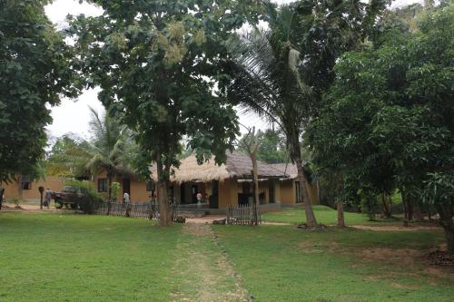 a house with a grass roof and a yard at WildEscape, Yala Blocks 3 & 5 in Buttala