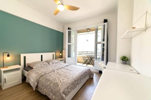une chambre avec un lit et une grande fenêtre dans l'établissement Appartement climatisé gare St-Charles, à Marseille