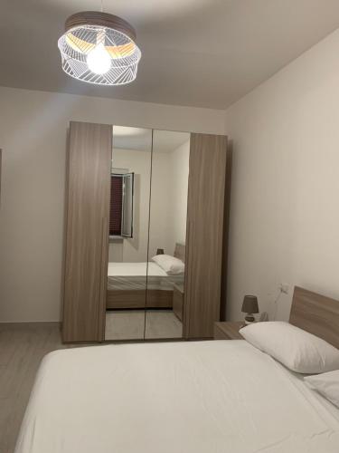 a bedroom with a white bed and a mirror at MARE.MORA Case vacanza Palinuro in Palinuro