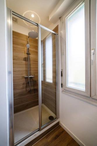 - une douche en verre dans une chambre avec fenêtre dans l'établissement Appartement climatisé gare St-Charles, à Marseille